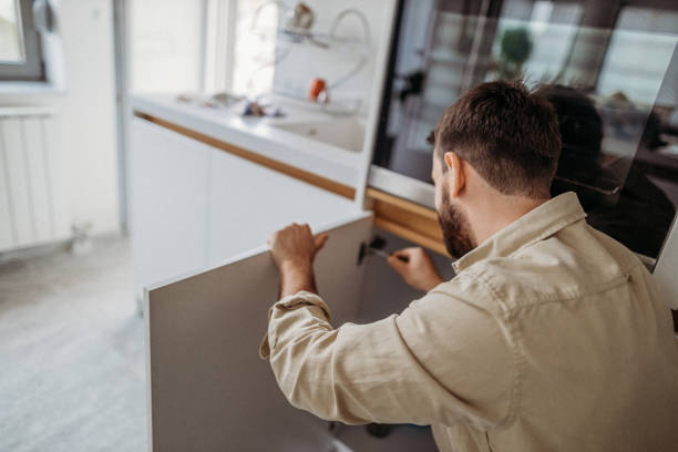 Man using tools to fix broken cabinet